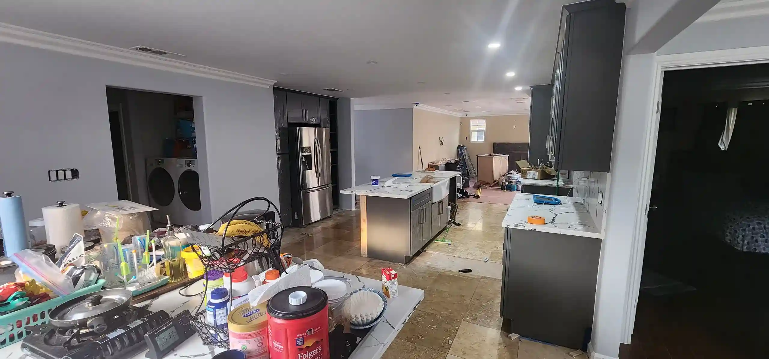 Modern renovated kitchen with dark cabinets, marble countertops and stainless steel appliances in Brooklyn home